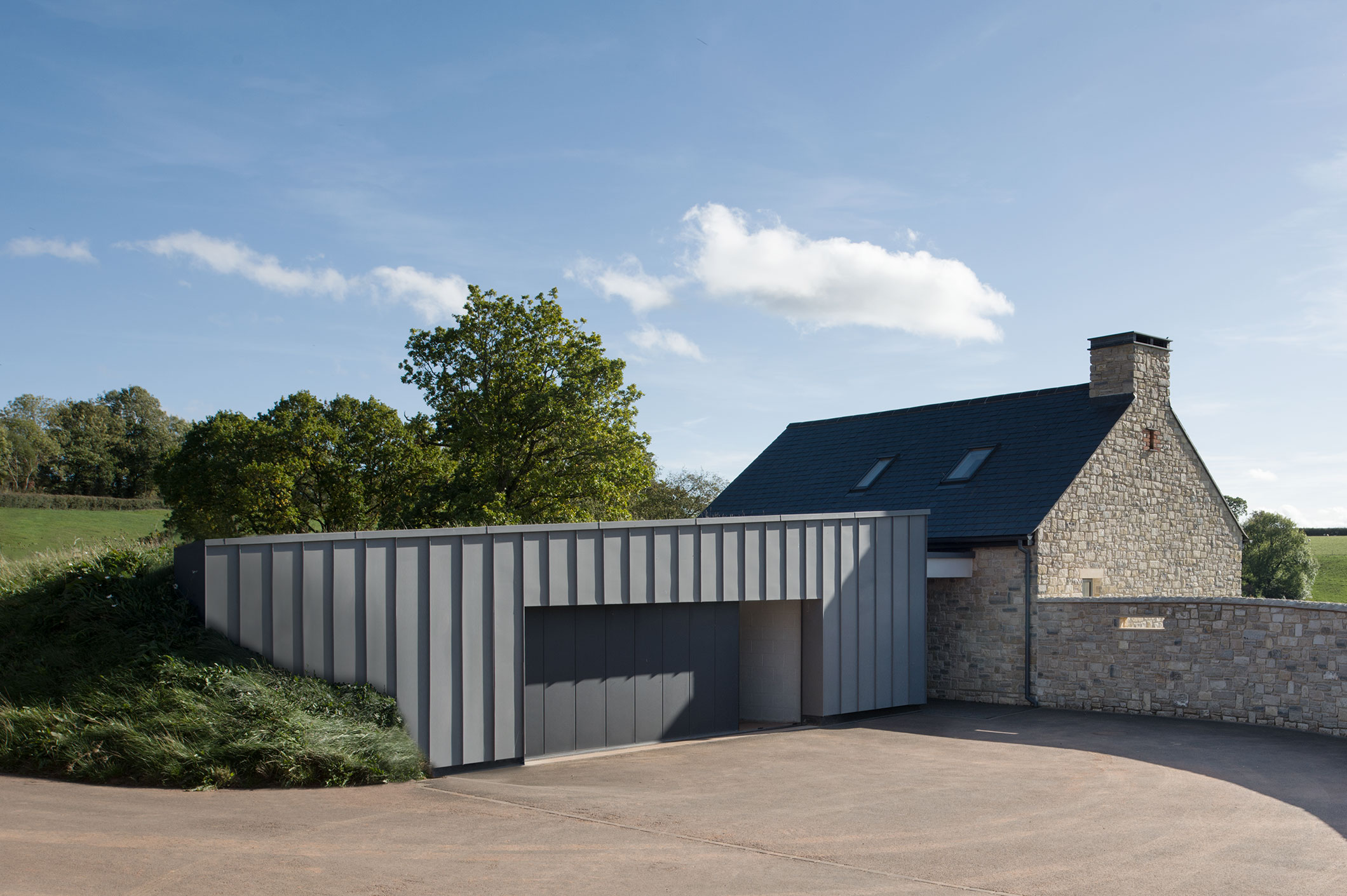 The visual impact of the garage is reduced under its green roof and surrounding banks